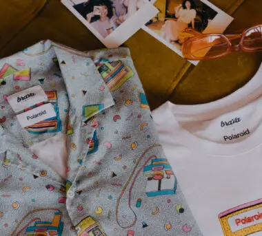 Colorful folded shirts by Brava and polaroid pictures