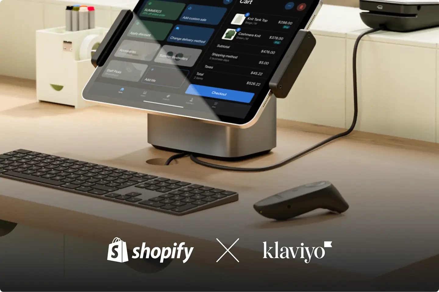 Tablet point-of-sale system on a desk with a keyboard and card reader. Shopify and Klaviyo logos are visible.