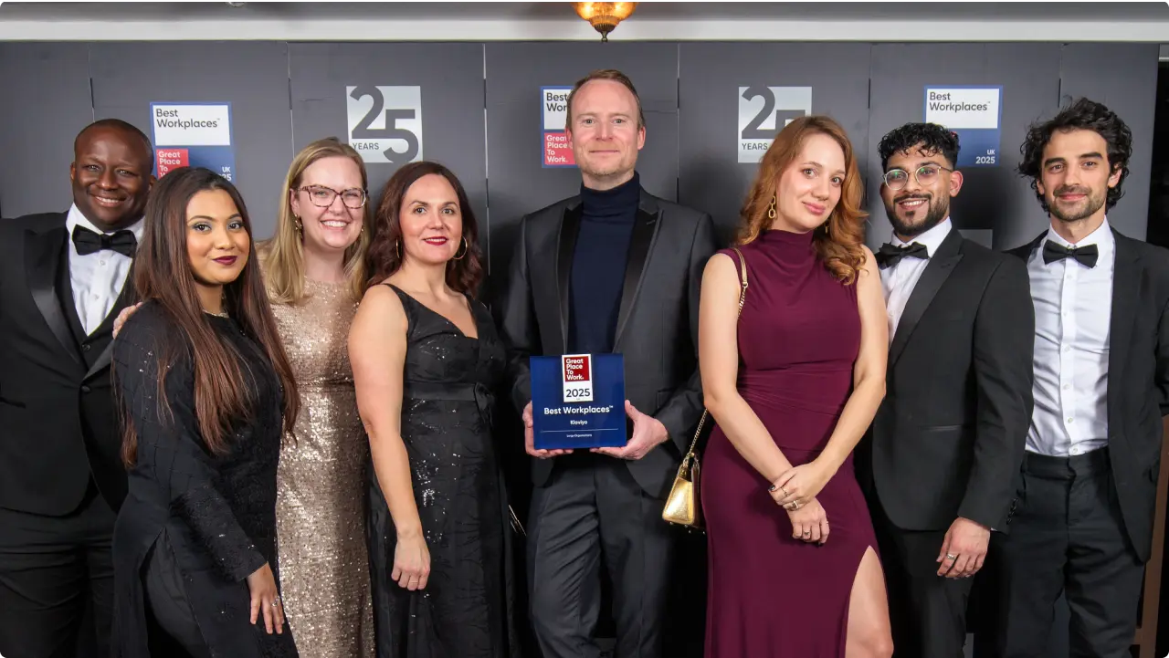 Snazzily dressed Klaviyos at UK's 2025 Best Workplaces Awards gala ceremony, holding an award that reads: Great Place to Work 2025 UK. Best Workplaces. Klaviyo. Large Organizations.