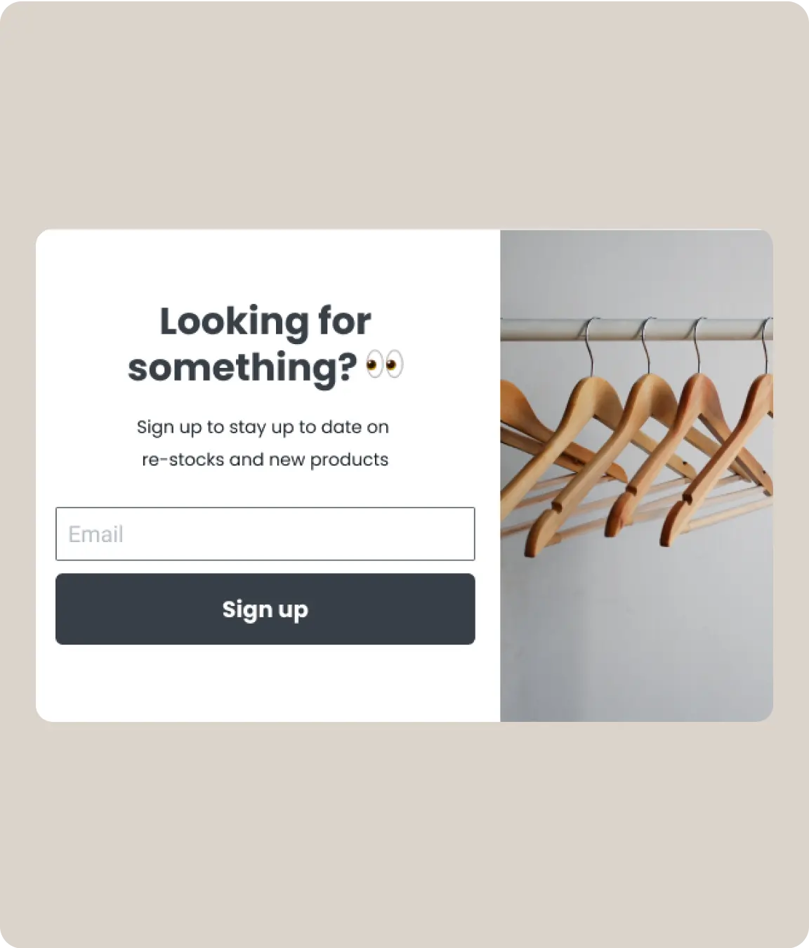 Email sign-up form with the text 'Looking for something?' encouraging users to stay updated on restocks and new products above field to enter email and ‘Sign up’ button. An empty clothing rack with wooden hangers is shown on the right.